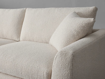 Vernon Sofa, an off-white two-seater sofa with textured fabric, two back cushions, two throw pillows, front-left view.