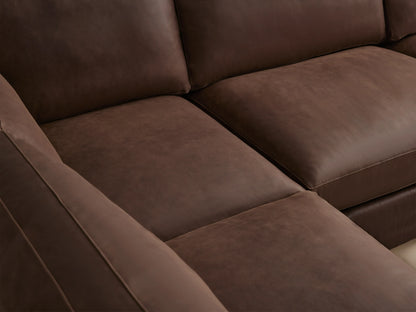 Brown leather Vernon sectional sofa with two pieces. Features plush cushions, straight arms, and a corner design on a wooden floor.
