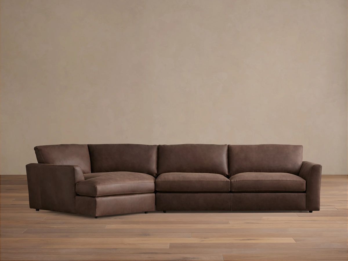 Vernon Leather Two-Piece Cuddle Chaise Sectional in rich brown leather. Left-side chaise, right armrest, plush cushions on hardwood floor.