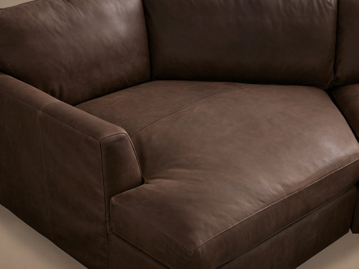 Vernon Leather Two-Piece Cuddle Chaise Sectional in rich brown leather, featuring plush cushions and a sleek design, set in a minimalistic room.