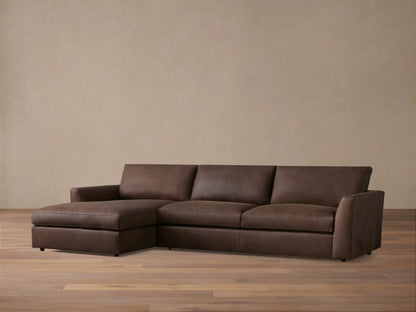 Brown Vernon Leather Two-Piece Chaise Sectional on wooden floor; left-side chaise, right-side three-seat sofa; neutral wall backdrop.