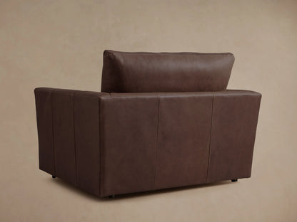 Brown leather Vernon Chair with plush cushions and visible stitching; features broad armrests and a sturdy backrest.