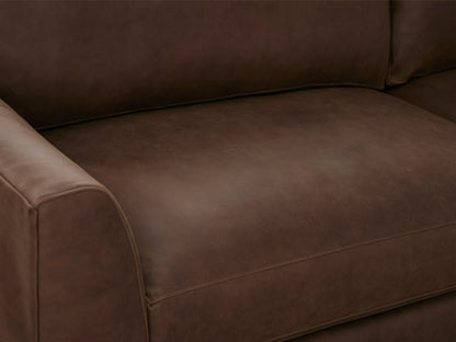 Vernon Leather Sofa close-up showing smooth, rich brown leather upholstery with visible natural variations on seat cushion and armrest.