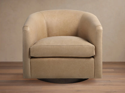 Light beige leather Bowan Swivel Chair, barrel-shaped with rounded arms and dark circular swivel base on a wood floor.