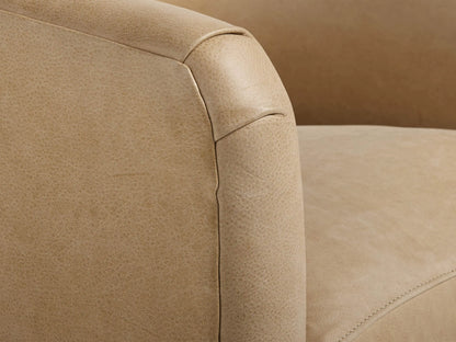 Light tan Bowan Leather Swivel Chair, front view, with a rounded barrel shape, plush seat cushion, and dark circular swivel base.