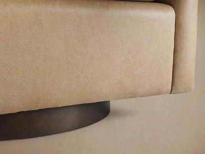 Close-up of Bowan Leather Swivel Chair's curved armrest and back in light tan, textured leather with visible stitching.