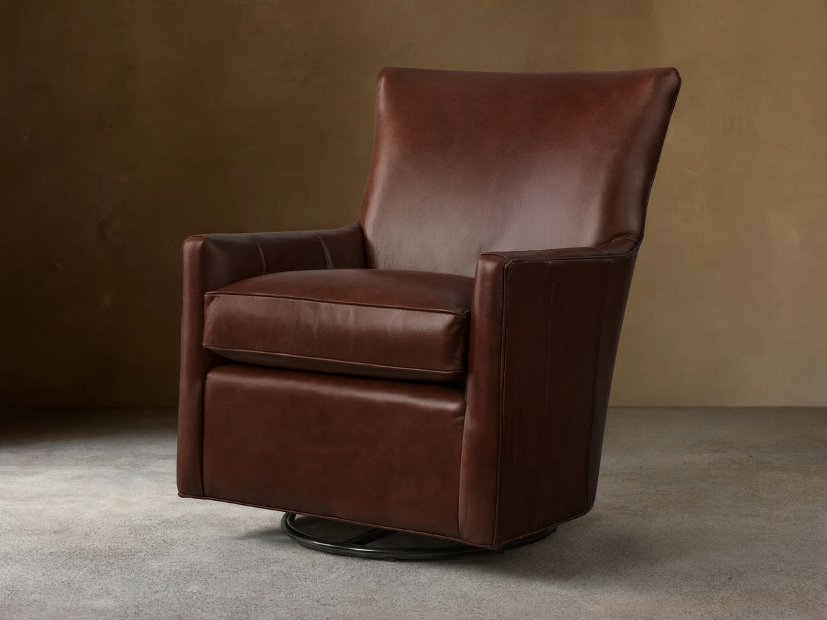 Front view of a brown Walton Leather Swivel Glider, with a cushioned seat and back, resting on a black circular swivel base.