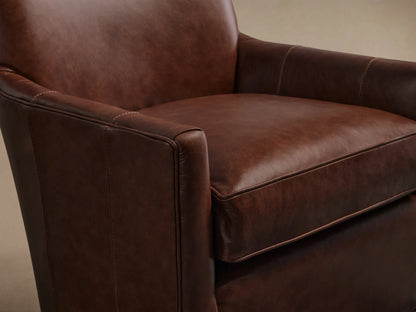 Angled Rear view of the brown Walton Leather Swivel Glider, showcasing vertical seam details on its high back and curved sides.