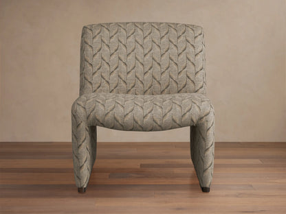 Reyna Chair, armless slipper chair with beige and dark grey leaf pattern fabric, angled on a hardwood floor.