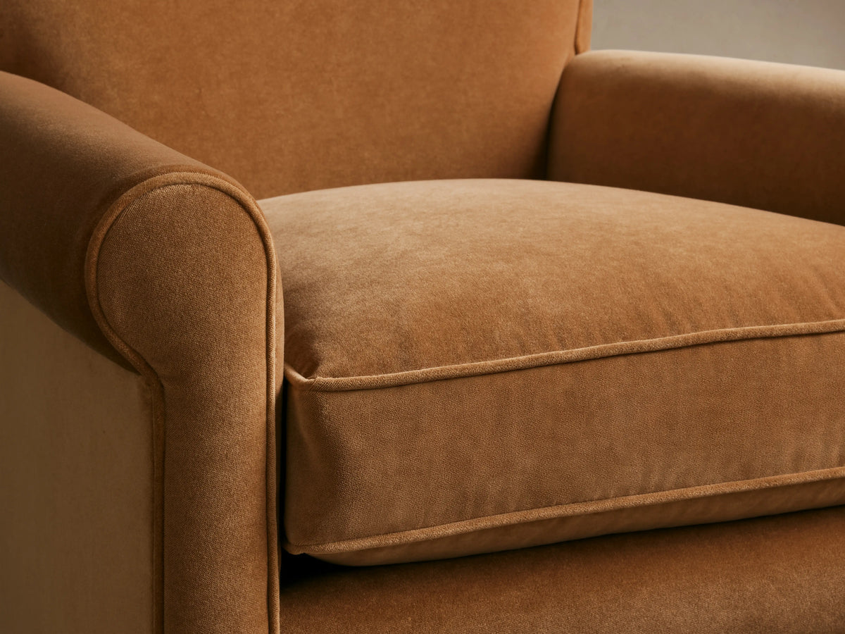 Rudy Rolled Arm Chair in cognac velvet, featuring rounded arms and plush seat cushion, showcasing soft fabric texture.