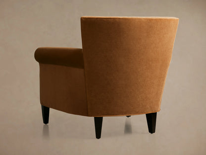 Rudy Rolled Arm Chair in cognac velvet with curved arms, plush seat cushion, and soft textured fabric.