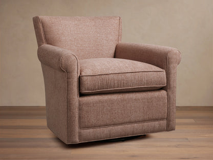 Rudy Rolled Arm Swivel Chair in light brown fabric, featuring rolled arms and a plush cushion on a wooden floor background.