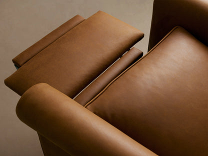 Rudy Leather Rolled Arm Swivel Recliner in brown leather, featuring rolled arms, cushioned back, and seat, on wood flooring.