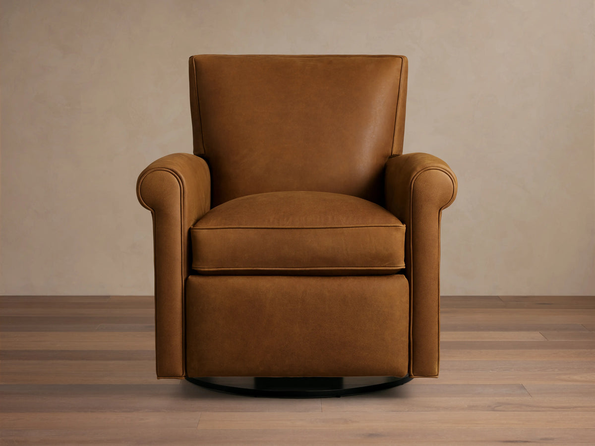 Rudy Leather Rolled Arm Swivel Recliner in rich brown leather, straight back, rounded arms, on wooden floor against a beige background.