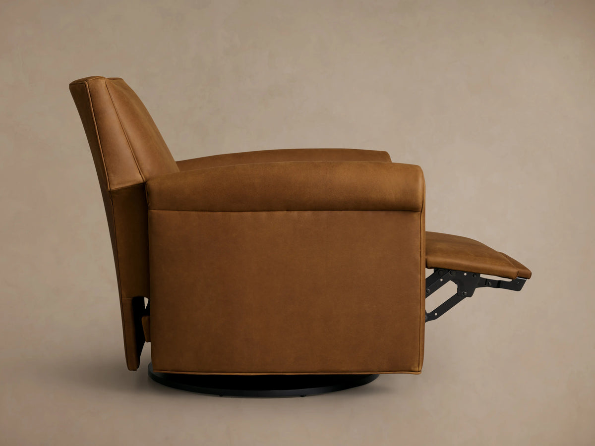 Brown leather swivel recliner with rolled arms, shown in side view. The footrest is extended. The chair has a solid base.