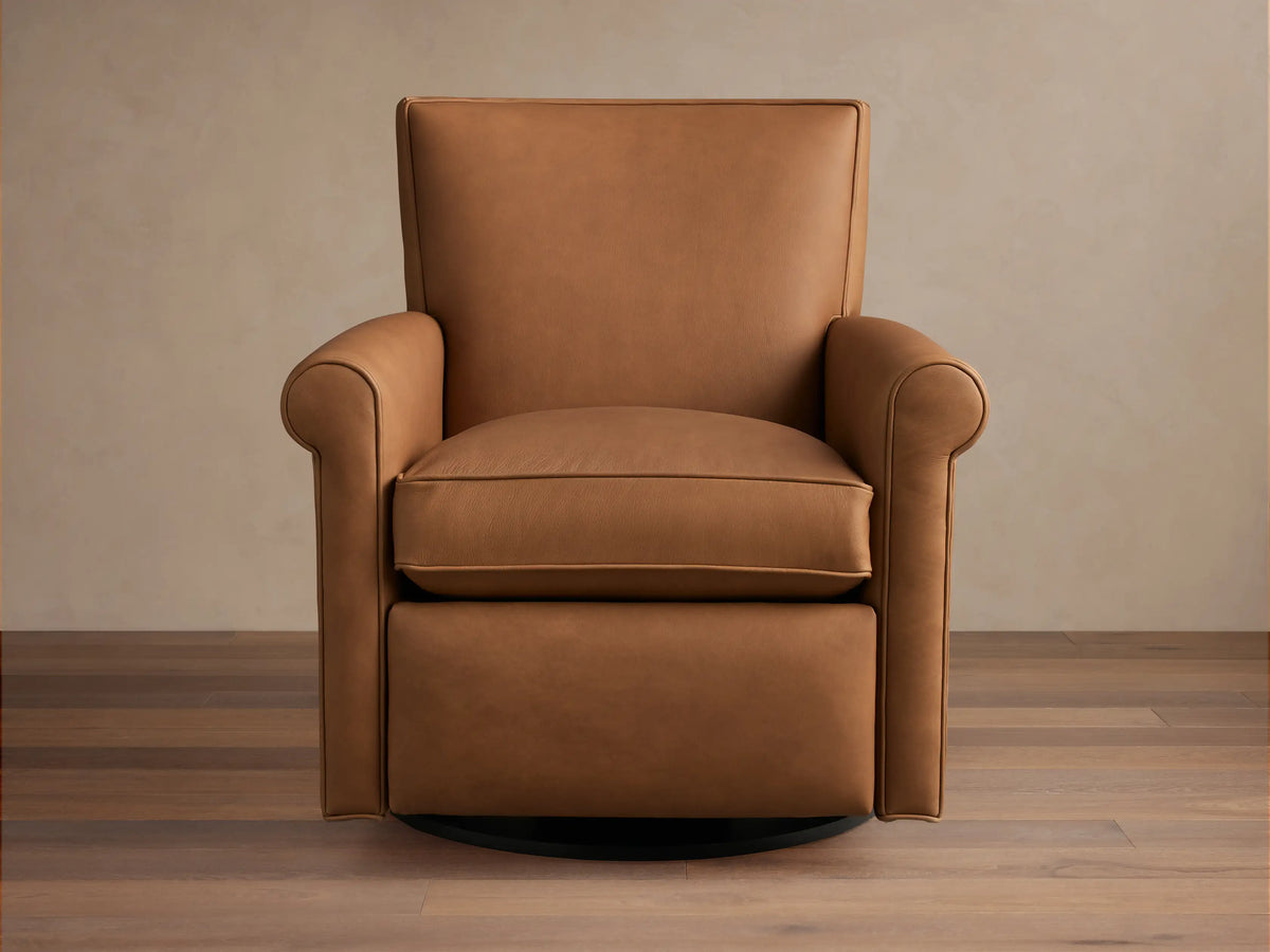 Rudy Leather Rolled Arm Swivel Recliner, a warm brown leather armchair with rolled arms & black swivel base, angled right.
