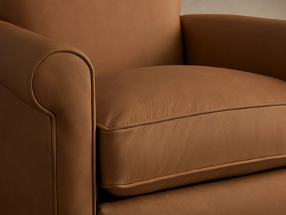 Rudy Leather Rolled Arm Swivel Recliner, tan leather, front view. Features rolled arms, plush seat cushion, and black swivel base.