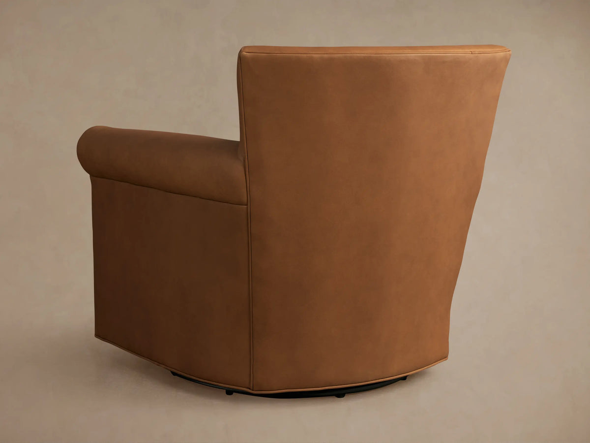 Close-up of the tan leather Rudy Swivel Chair, highlighting the rolled armrest and piped seat cushion detail.