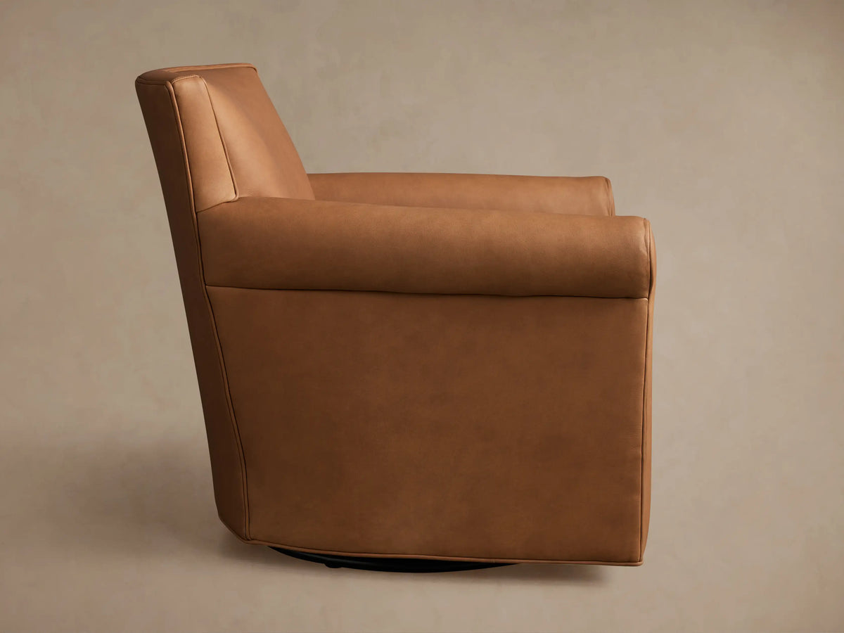 Back-left view of the Rudy Leather Rolled Arm Swivel Chair in smooth camel brown leather, featuring a dark swivel base.