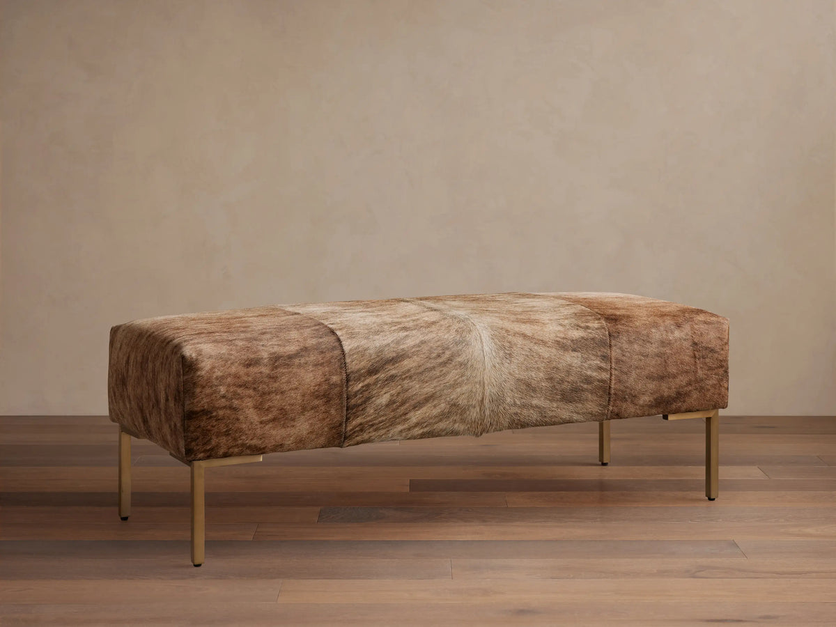 Tilton Hair on Hide Bench: long, rectangular, with paneled blonde and brown brindle hide, on four golden metal legs.