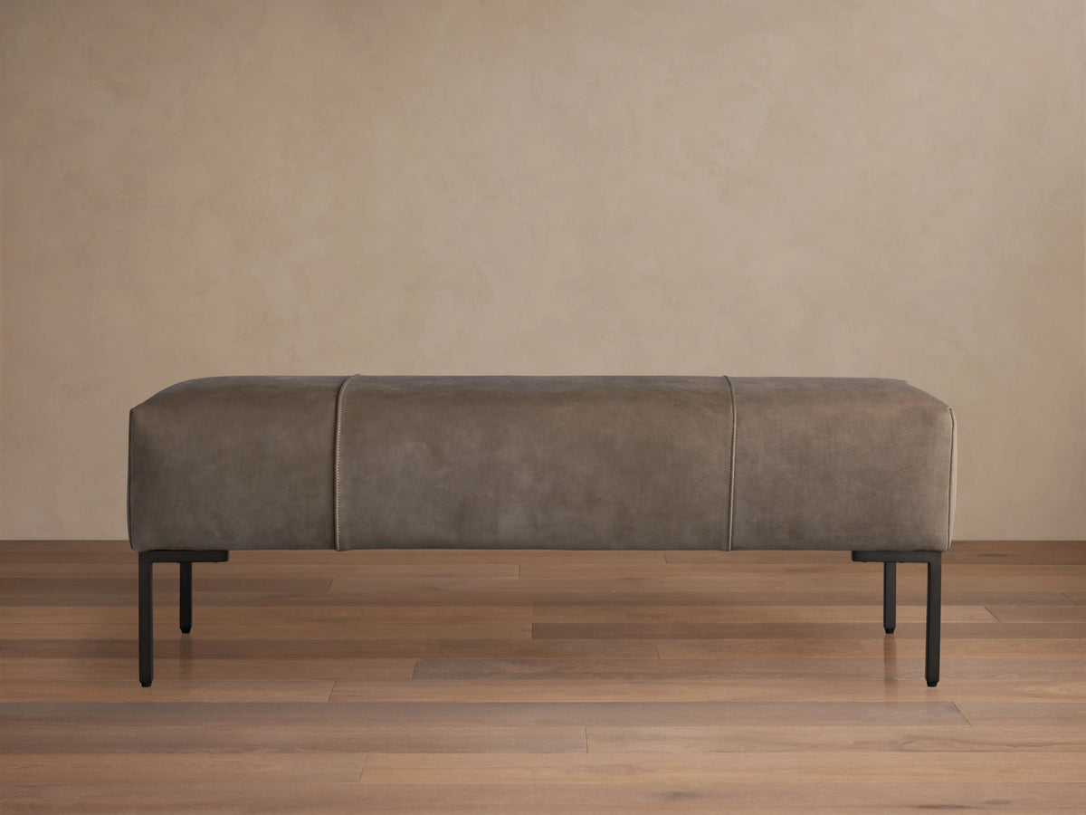 Tilton Nubuck Leather Bench with dark, velvet-like nubuck leather upholstery on a sleek design. Supported by thin golden legs.