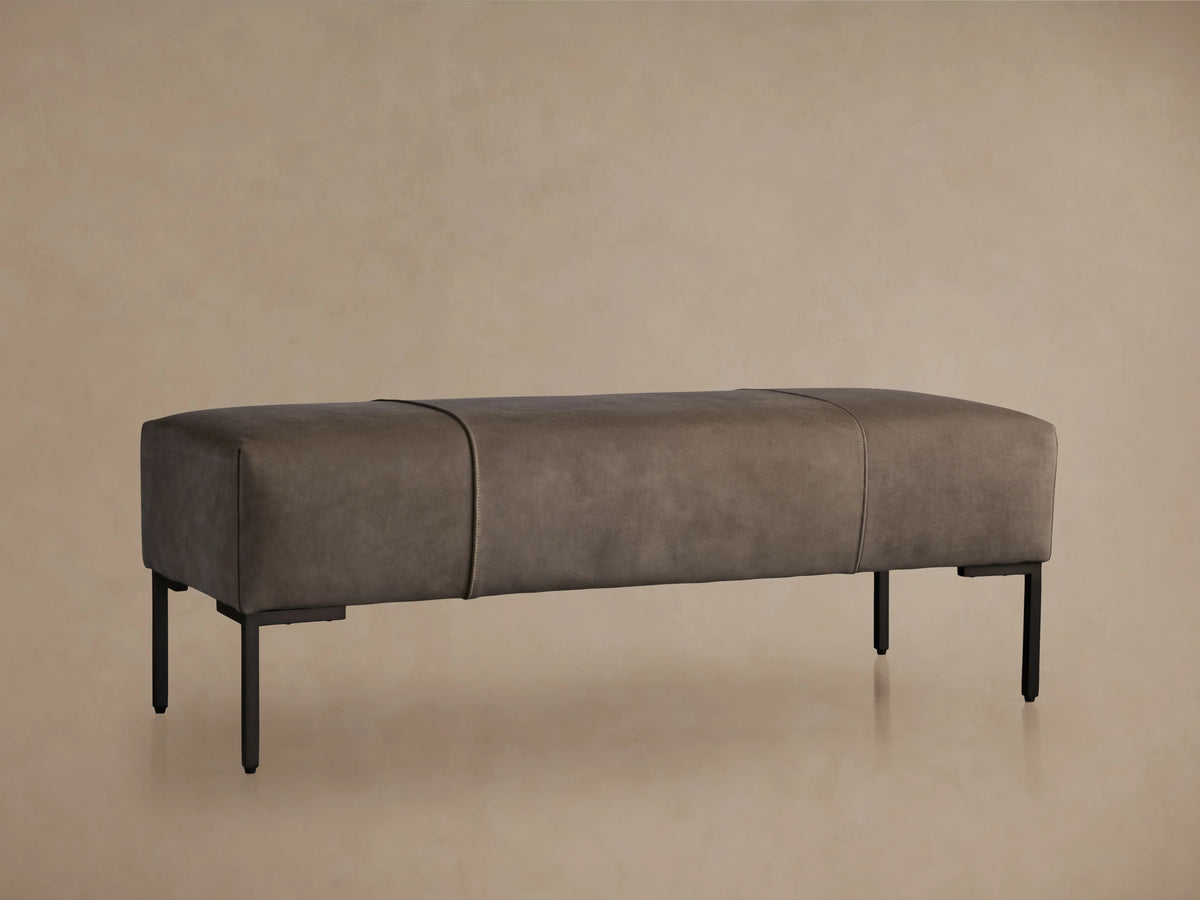 Tilton Nubuck Leather Bench with a dark, velvet-textured surface, resting on light wooden legs against a neutral background.