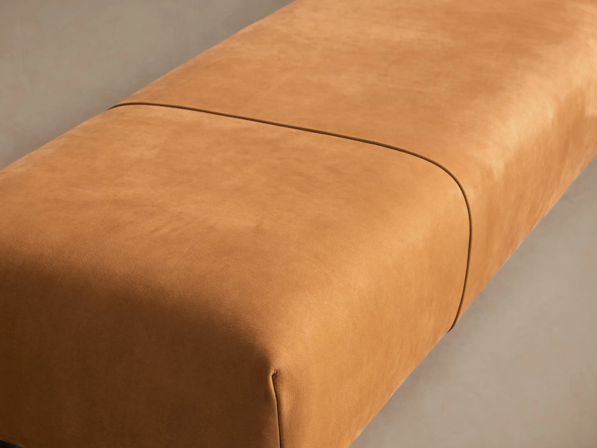 Long, rectangular Tilton Leather Bench upholstered in warm tan leather, with two seams and minimalist black metal legs.