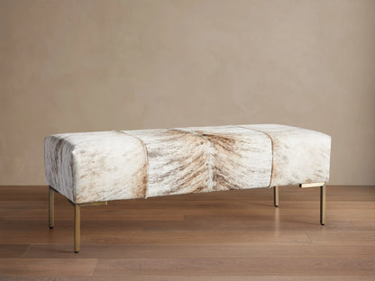 Tilton Hair on Hide Ottoman, a long rectangular bench with blonde brindle hide upholstery and thin gold metal legs.