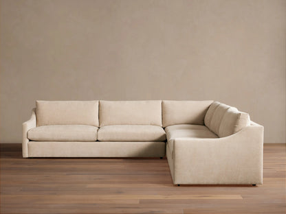 Kipton Slope Arm Three-Piece Corner Sectional in light beige fabric, L-shaped with subtly sloped arms, on a wood floor.
