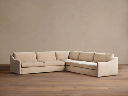 Kipton Slope Arm Three-Piece Corner Sectional in light beige fabric, L-shaped with subtly sloped arms, on a wood floor.
