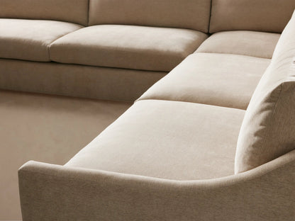 Light beige Kipton Slope Arm Three-Piece Corner Sectional, L-shaped with gentle curved arms, against a neutral wall.