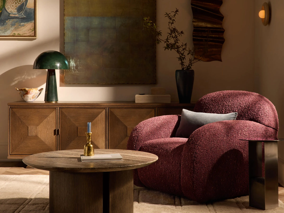 Algiers Chair, light cream bouclv© textured armchair with rounded back and arms, angled left on a wooden floor.