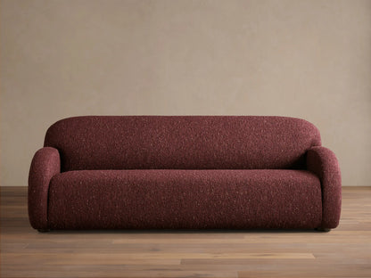 Front view of the deep red speckled Algiers Sofa, featuring rounded arms and a sleek, low-profile design.