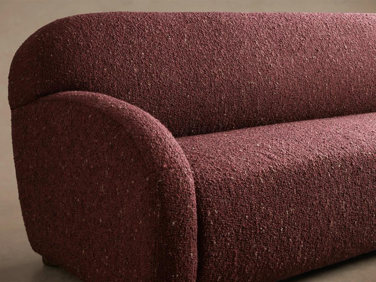 Front view of the burgundy speckled Algiers Sofa with a modern, rounded silhouette and armrests.