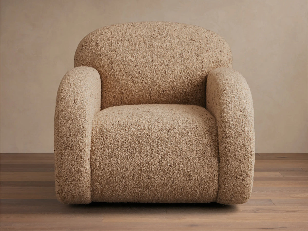 Close-up of the oatmeal bouclv© fabric upholstery on the Algiers Swivel Chair, highlighting its curved form.