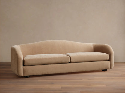 Ashlyn two-seat sofa with a curved back and integrated arms, upholstered in a light tan textured fabric.