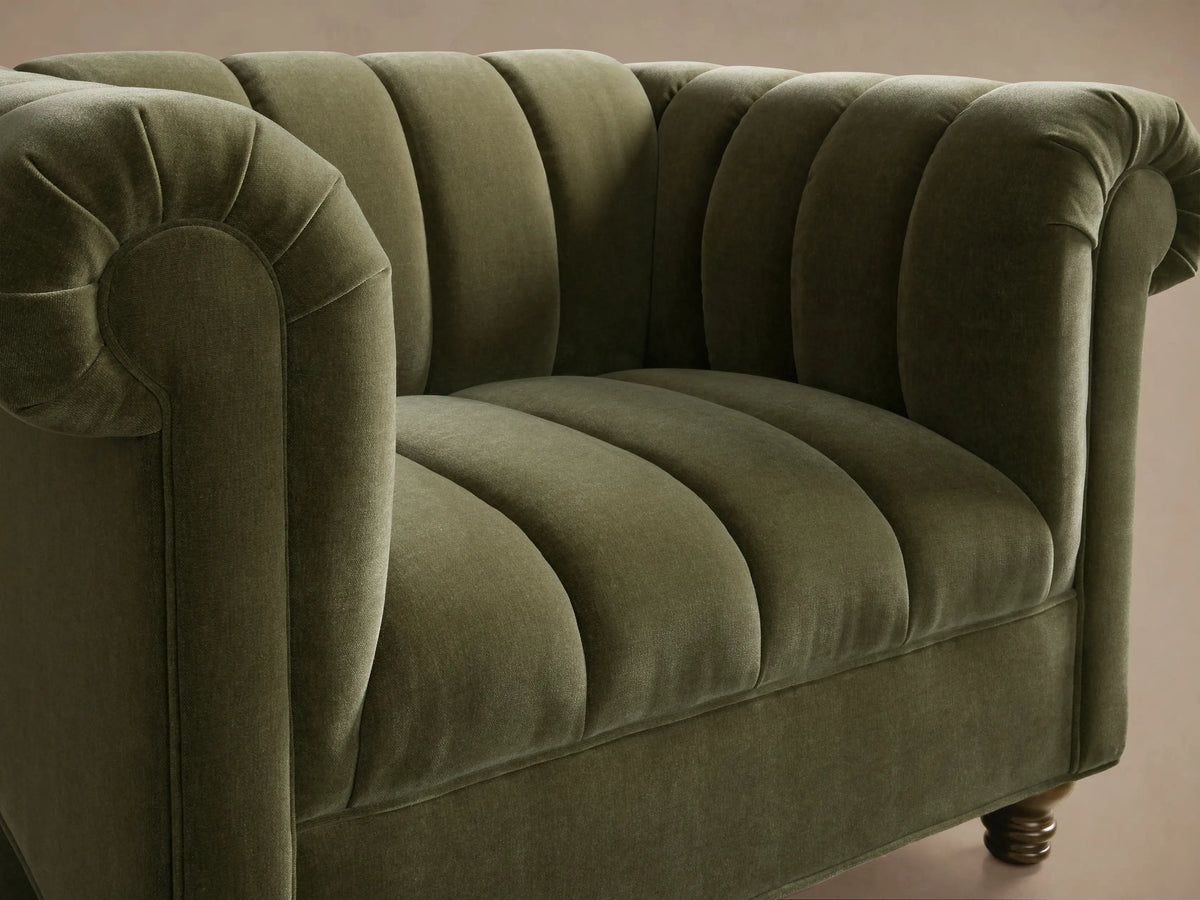 Front view of the olive green Berwick Channeled Chair with vertical channeling, rolled arms, and turned wooden legs.