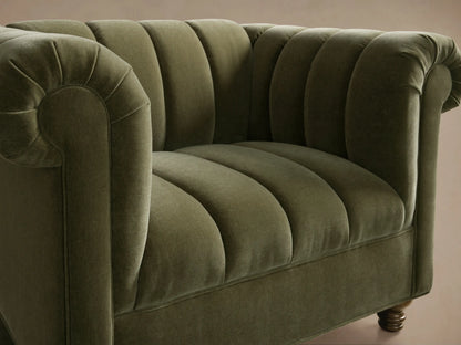 Front view of the olive green Berwick Channeled Chair with vertical channeling, rolled arms, and turned wooden legs.