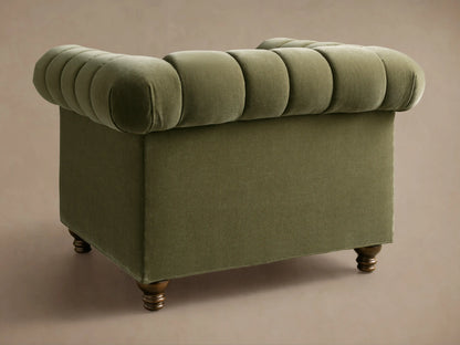 Close-up of olive green Berwick Channeled Chair, velvet upholstery with rolled arms, channeled back and seat cushions, dark wood legs.