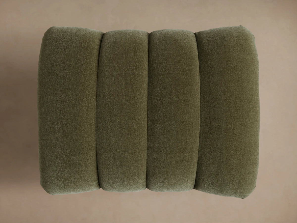Close-up of the Olive Berwick Channeled Ottoman, showing channeled velvet top and dark turned wood legs.