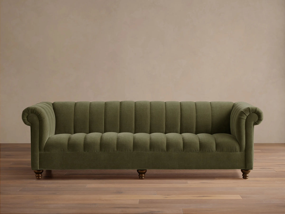 Front view of the olive green Berwick Channeled Sofa with channel-stitched back and seat, rolled arms, and turned wooden legs.