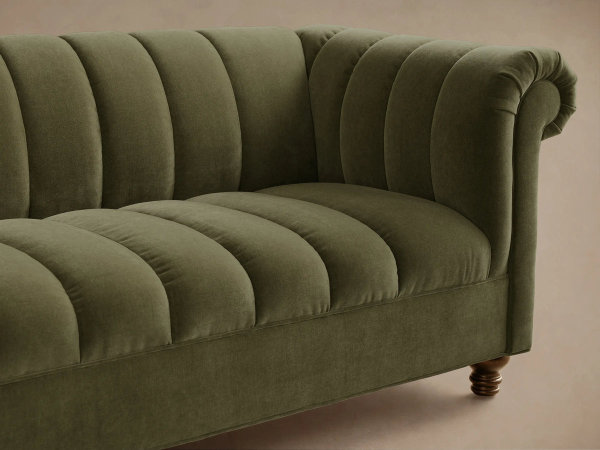 Front view of an olive green Berwick Channeled Sofa, featuring channel-stitched back and seat cushions, rolled arms, and dark wood legs.