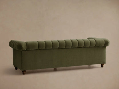 Angled view of an olive green Berwick Channeled Sofa, showing vertical channeling on back and seat cushions, with a rolled arm.