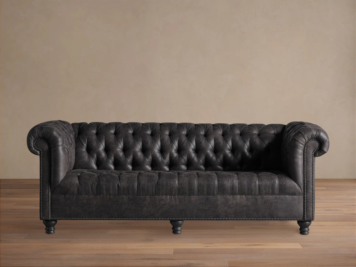 Berwick Faux Leather Sofa, dark steel grey, Chesterfield style with deep tufting, rolled arms, and nailhead trim.