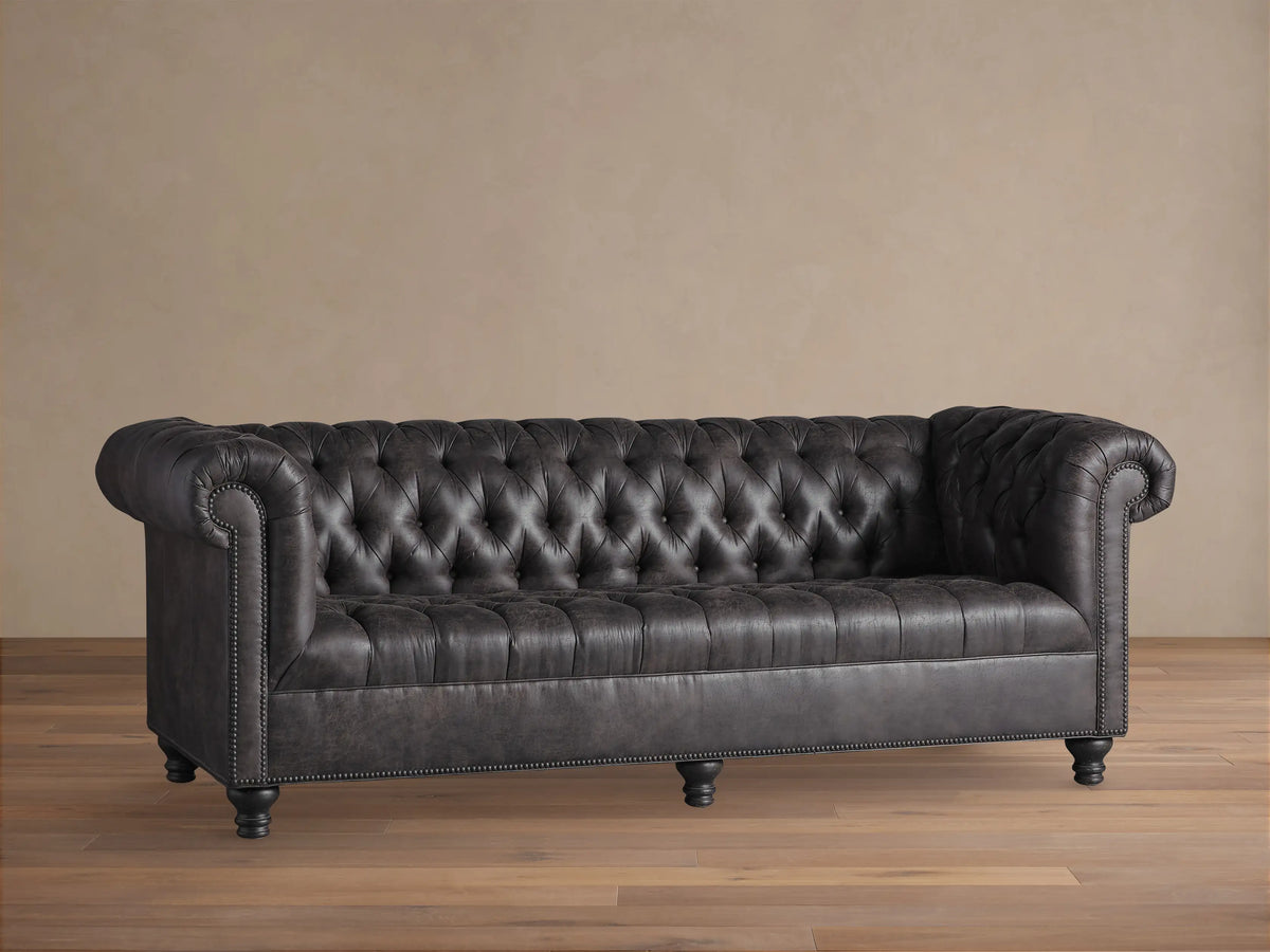 Berwick Faux Leather Sofa, dark steel grey, Chesterfield style with deep tufting, rolled arms, and nailhead trim.