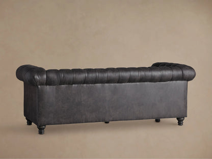 Distressed dark gray Berwick Faux Leather Sofa, deeply tufted back/seat, rolled arm with decorative nailhead trim.