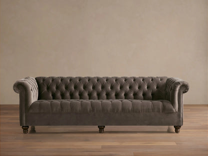Berwick Sofa: Tufted mink velvet Chesterfield sofa with rolled arms and dark turned legs, against a neutral wall.