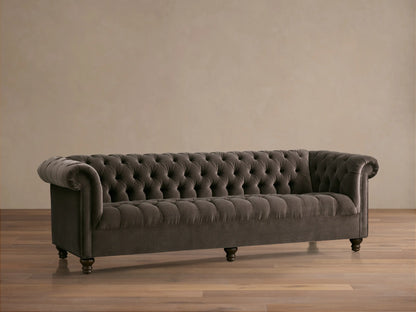 Berwick Sofa: Tufted mink velvet Chesterfield sofa with rolled arms and dark turned legs, against a neutral wall.