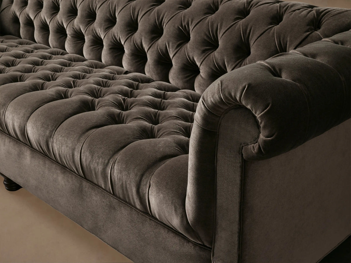 Berwick Sofa, dark gray velvet, classic Chesterfield style with deep tufting, rolled arms, and dark wooden legs.