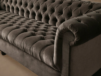 Berwick Sofa, dark gray velvet, classic Chesterfield style with deep tufting, rolled arms, and dark wooden legs.